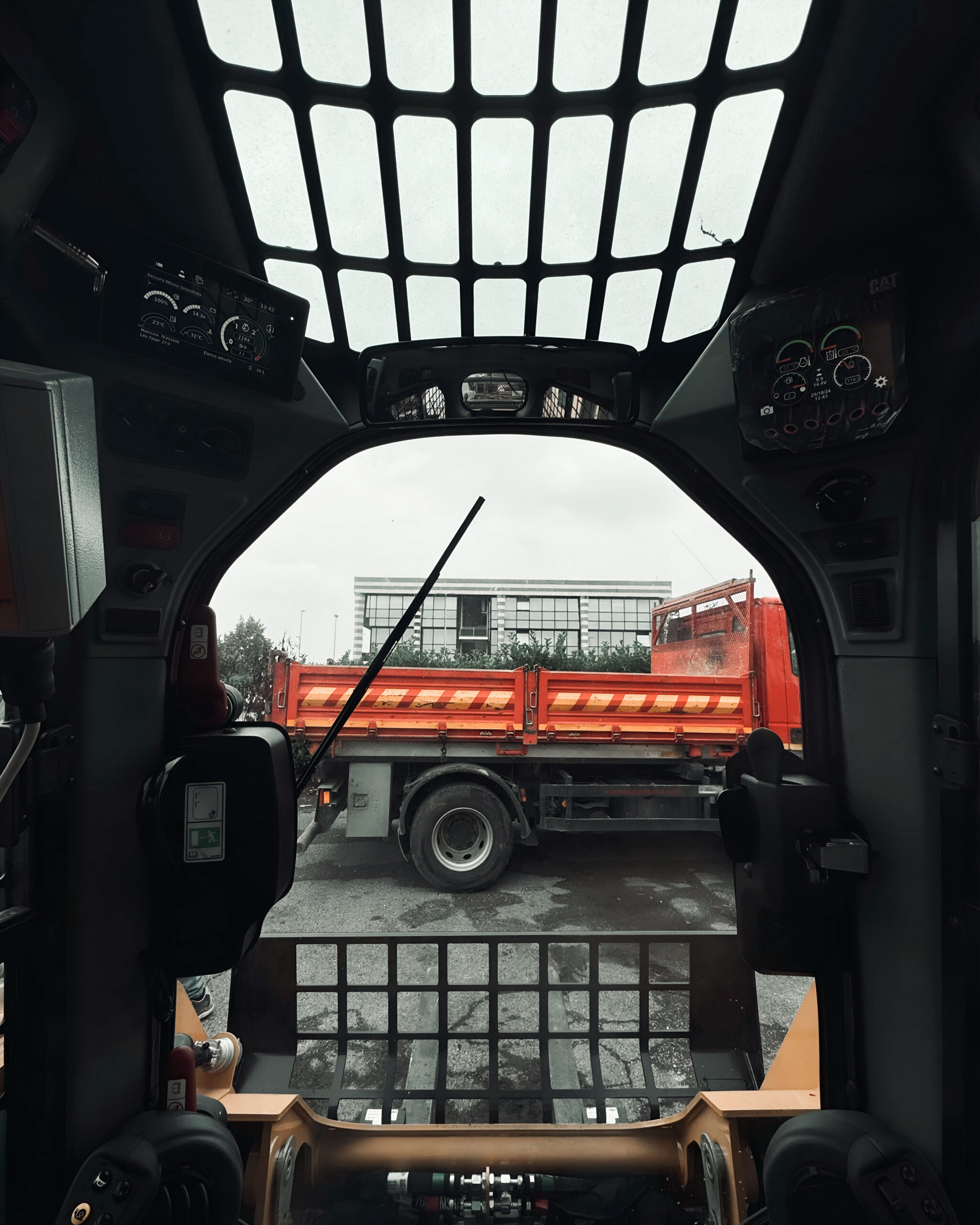 Cabina escavatore con vista camion – Impresa scavi Brescia